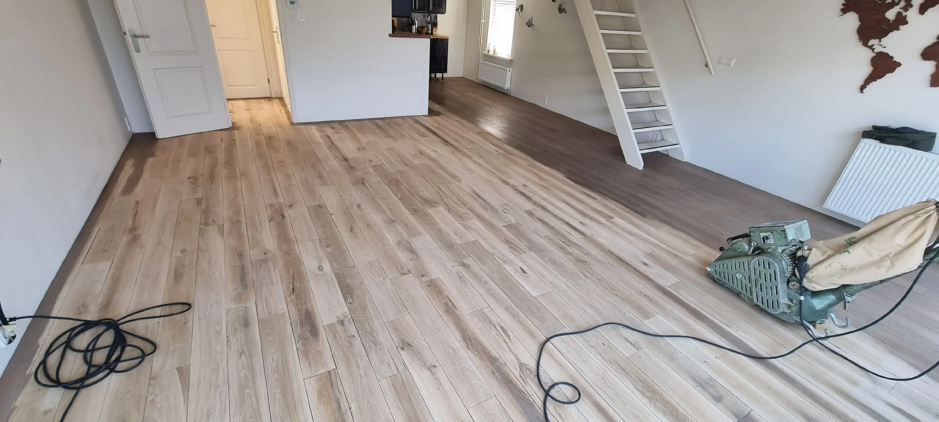 Vakman is een eiken houten vloer stofvrij aan het schuren in Noord-Holland
